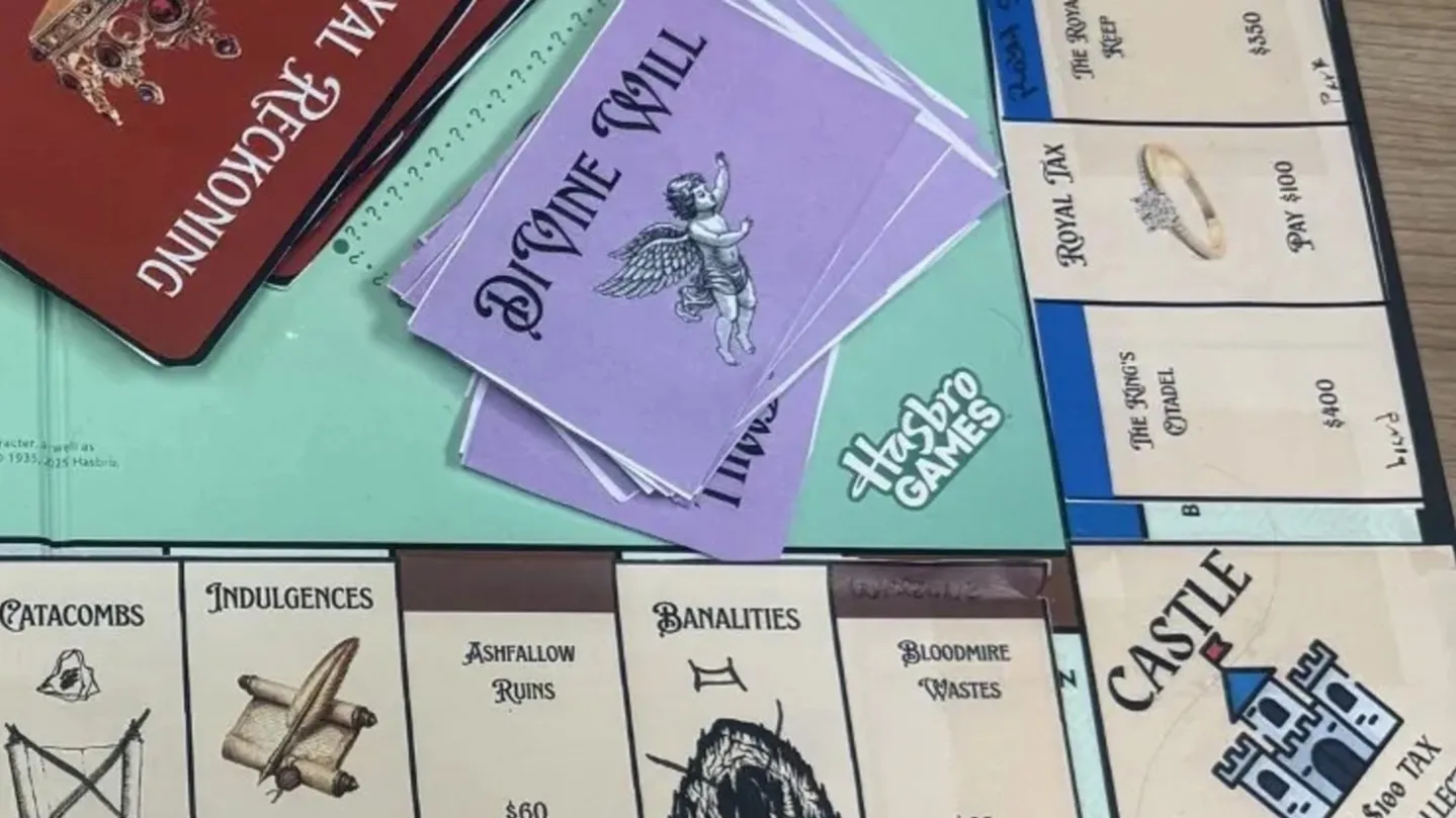 The GO corner of Feudopoly, a student redesign of Monopoly: a castle in place of GO, and property spaces renamed Catacombs, Indulgences, Ashfallow Ruins and Bloodmire Wastes, beside a Divine Will deck