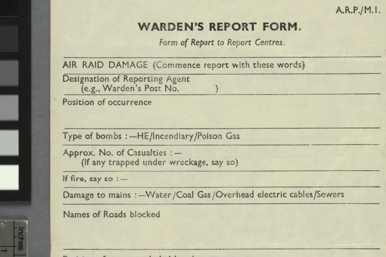 An Air Raid Precautions Warden's Report Form, photographed in an archive beside a grey scale card, with blank fields for the type of bombs, casualties, fire, and damage to mains
